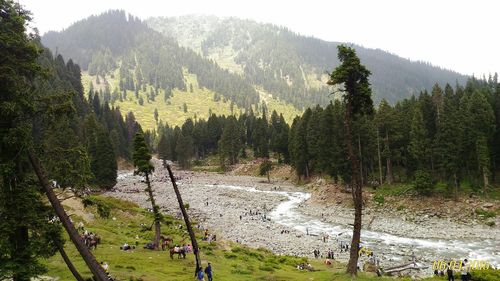 High angle view of people by river and mountains