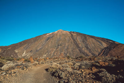 View of volcanic mountain against blue sky