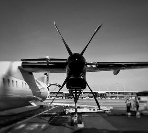 Airplane on airport runway against sky