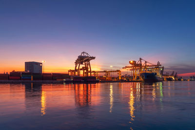 Commercial dock at sea against sky during sunset