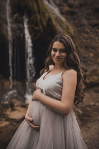 Portrait of young woman sitting on rock