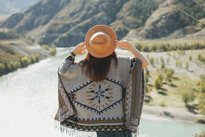 Rear view of woman standing against mountain