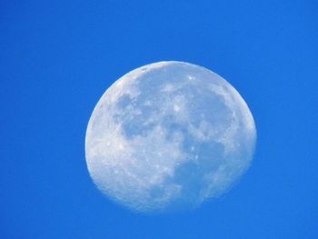 Low angle view of moon against blue sky