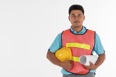 Portrait of young man standing against white background