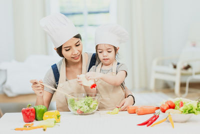 Midsection of woman having food in kitchen