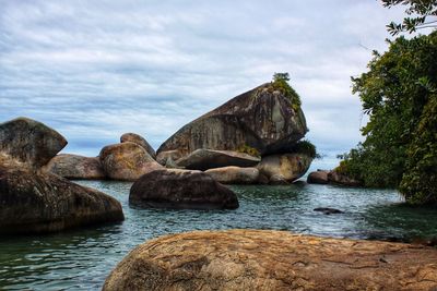 Rocks in sea against sky