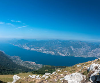 Aerial view of landscape and mountains against blue sky