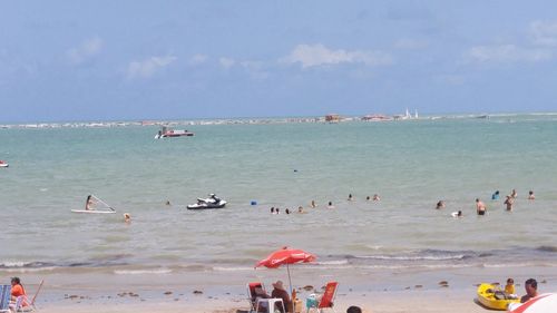 People on beach against sky