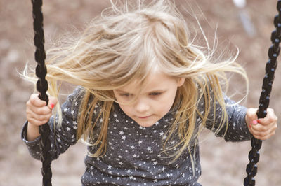 Portrait of girl holding on a swing 