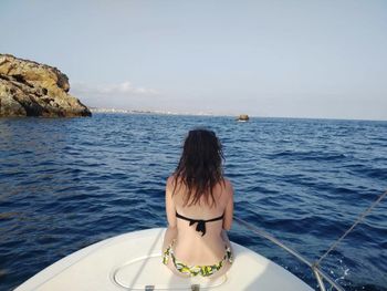 Rear view of woman in sea against sky