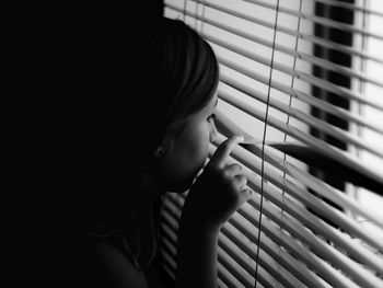 Portrait of girl looking through window