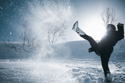 Woman playing on snowy field during winter season