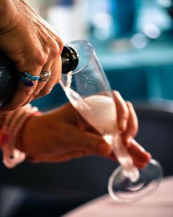 Cropped hands pouring champagne into flute