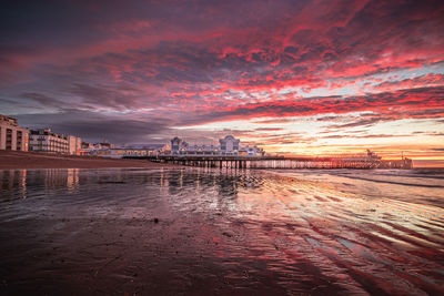 View of beach against cloudy sky during sunset