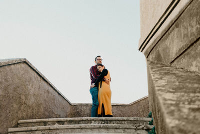 Side view of woman standing against building