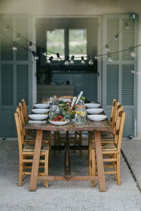 Light bulbs hanging over dining table with chairs at backyard patio