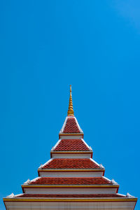 The temple roof stands out against the turquoise backdrop.