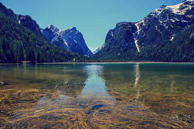 Scenic view of lake and mountains against clear sky