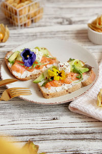 Aesthetic appetizer breakfast with cottage cheese, salmon, avocado, edible flowers. pescetarian diet
