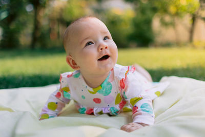 Portrait of cute baby boy lying on bed at park