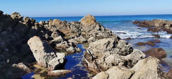 Panoramic view of rocks on beach against sky