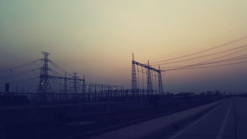 Electricity pylon against sky during sunset