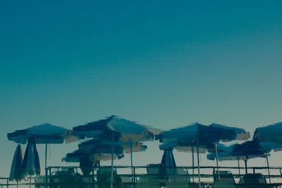 Houses on beach against clear blue sky