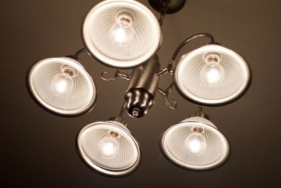 Low angle view of illuminated chandelier hanging from ceiling