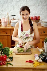 Portrait of woman preparing food on kitchen island at home