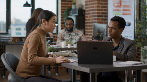 Businesswoman using laptop while sitting at cafe