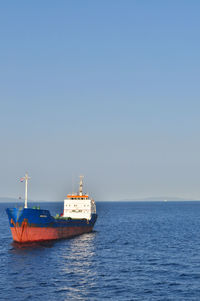 Boats in sea against clear sky