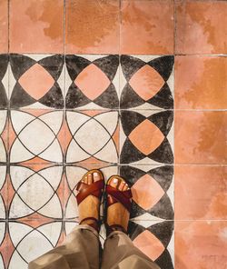 Low section of person standing on mosaic floor