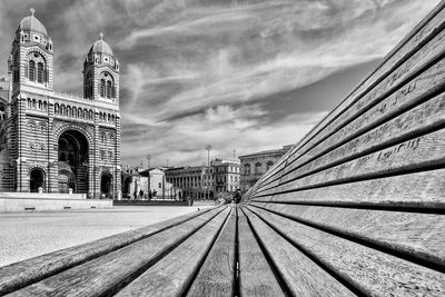 Low angle view of railroad tracks amidst buildings against sky