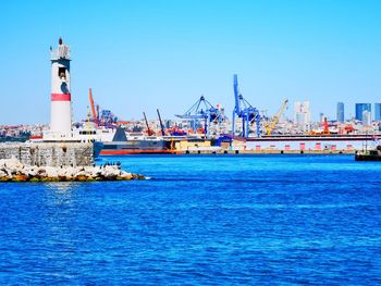 Commercial dock by sea against blue sky