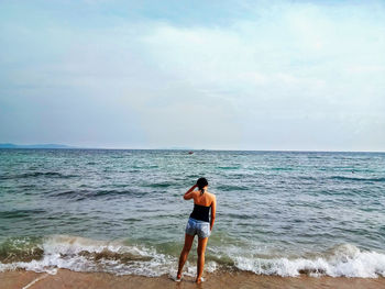 Rear view of woman standing on beach