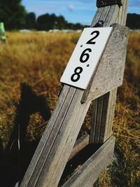 Close-up of numbers on wooden post