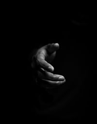 Close-up of human hand against black background