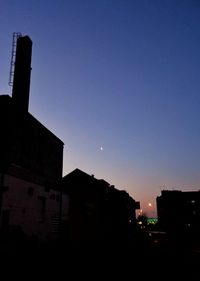 Low angle view of silhouette buildings against sky at sunset