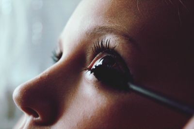 Close-up of woman applying mascara