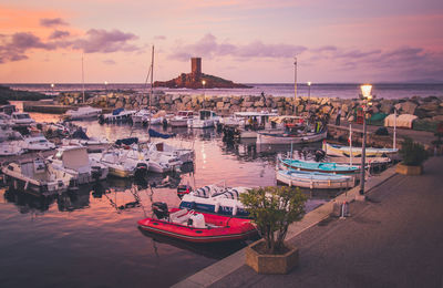 High angle view of boats moored at harbor during sunset