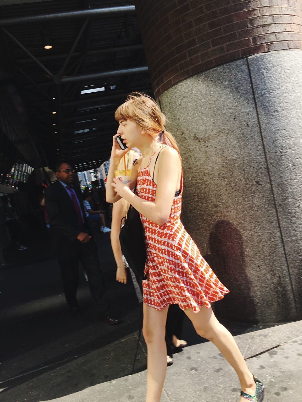 YOUNG WOMAN LOOKING AWAY WHILE STANDING ON ROAD