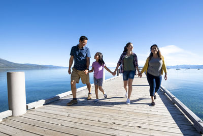 A family walks on a pier on a beautiful day in south lake tahoe, ca