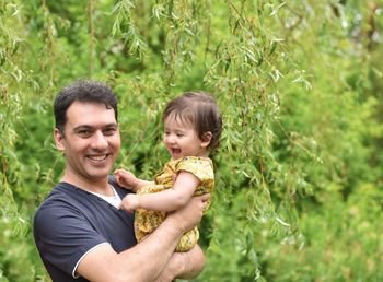 Portrait of father and son against plants