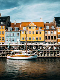 Boat moored in canal by buildings in city