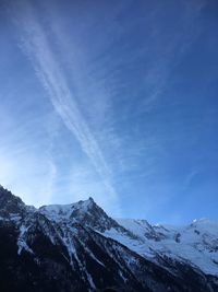 Scenic view of snowcapped mountains against blue sky