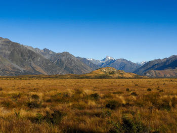 Scenic view of desert against clear blue sky