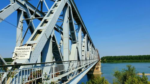 Bridge over river against clear blue sky