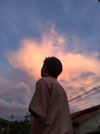 Rear view of man standing against sky during sunset