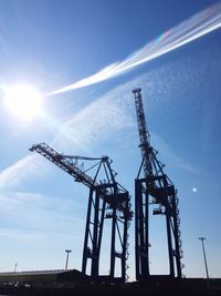 Low angle view of cranes against sky