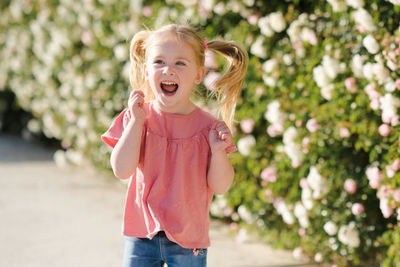 Cute girl laughing against plants